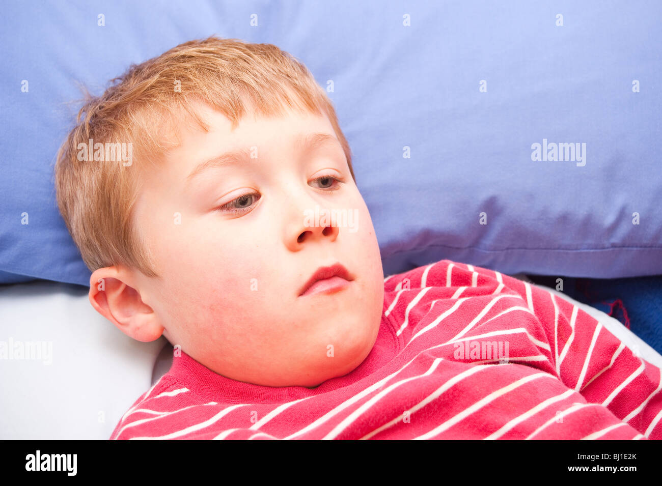 A MODEL RELEASED picture of a 6 year old boy laying down feeling ill in the uk Stock Photo Alamy