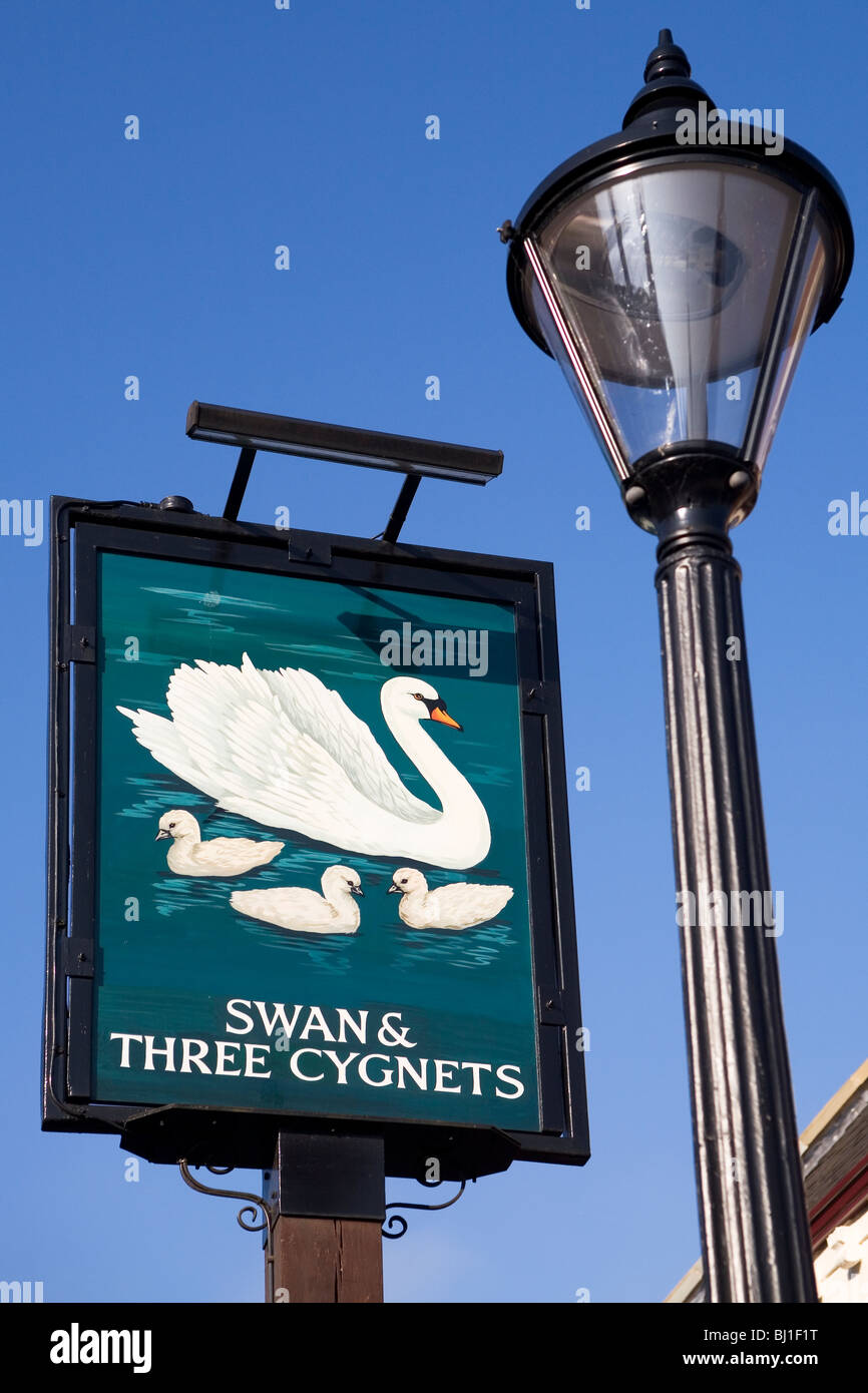 A typical British pub sign. The pub is called the Swan and three cygnets. Stock Photo