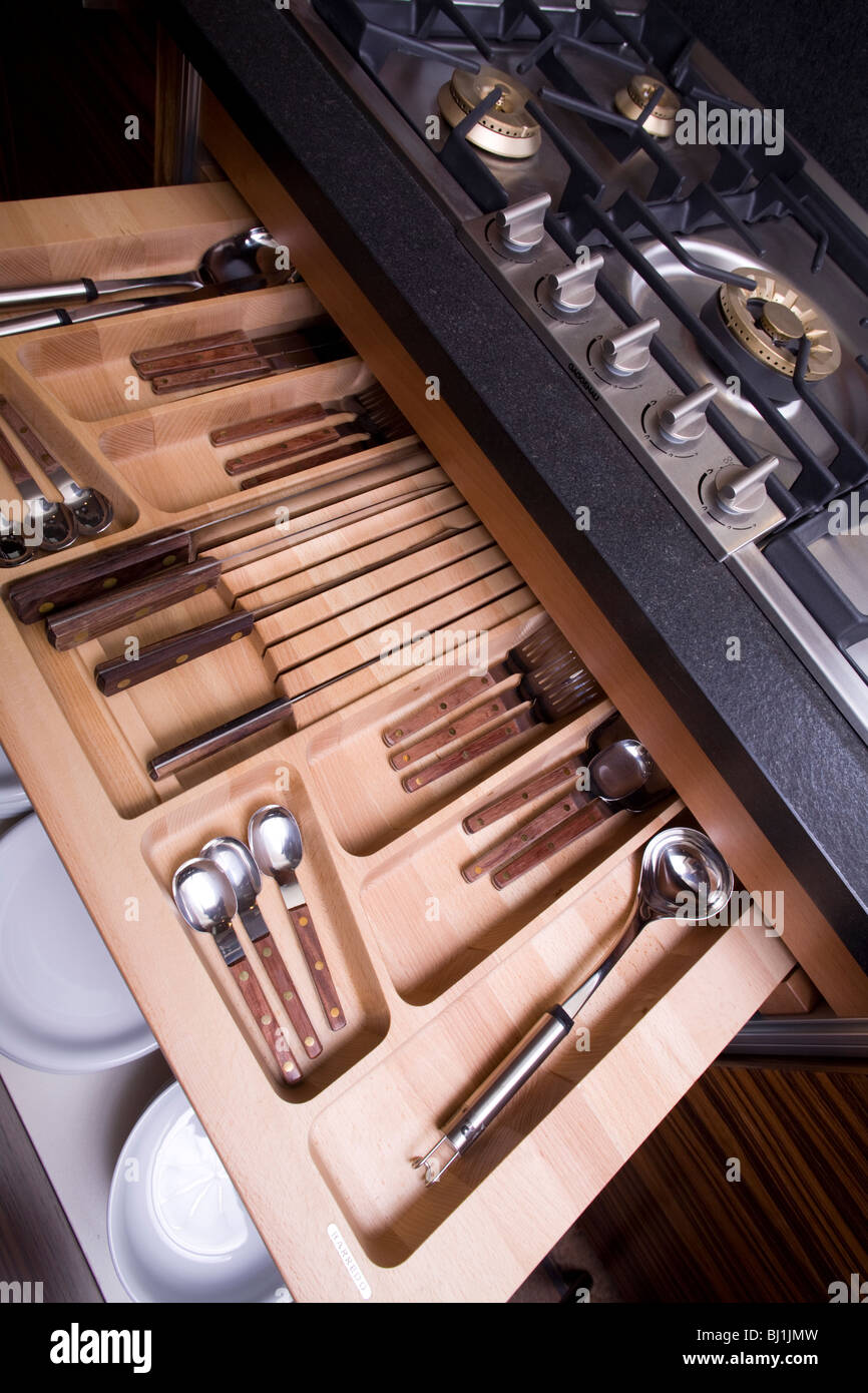 Modern kitchen details drawers with silverware and dishes under the