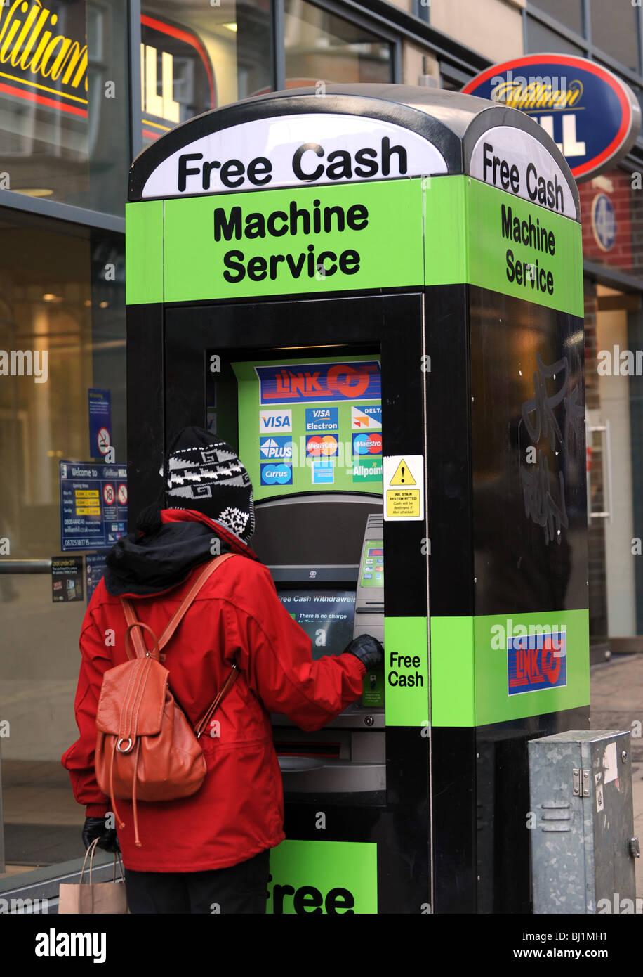 Woman using Free Cash machine service England Uk Stock Photo