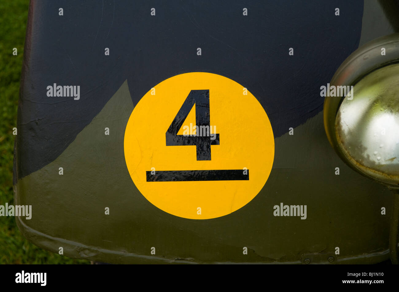 Number 4 in a yellow circle on the front mudguard of a camouflaged, vehicle Stock Photo