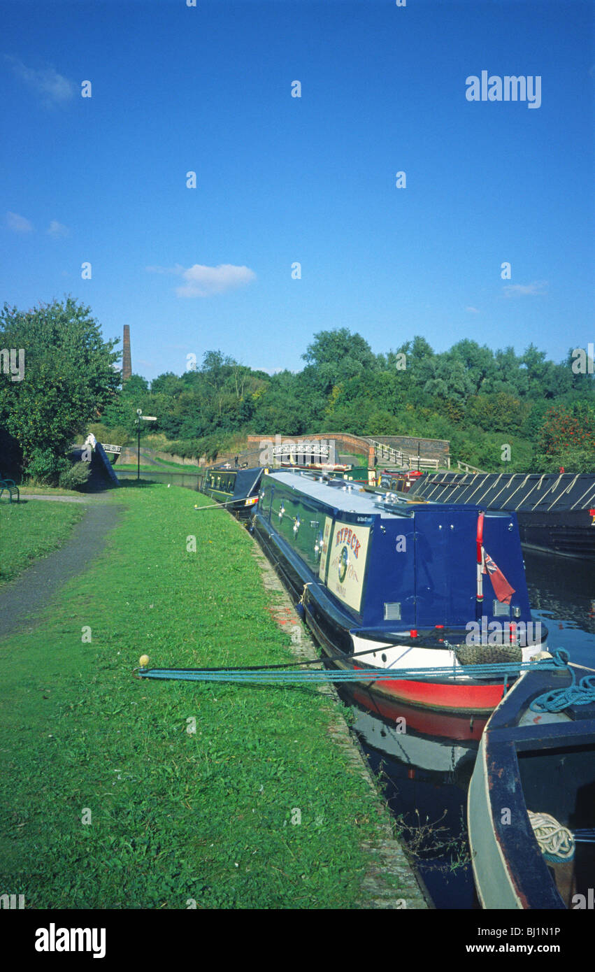 Canal Boats on No2 Dudley Canal at Bumble Hole with Darby End Pumping House and Chimney in the background Stock Photo