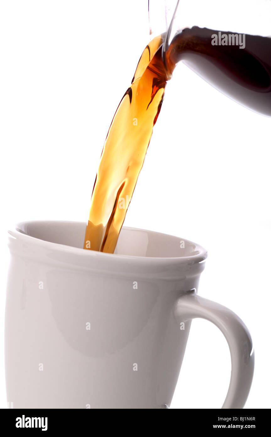 tilted vertical close up coffee being poured into a coffee cup Stock Photo