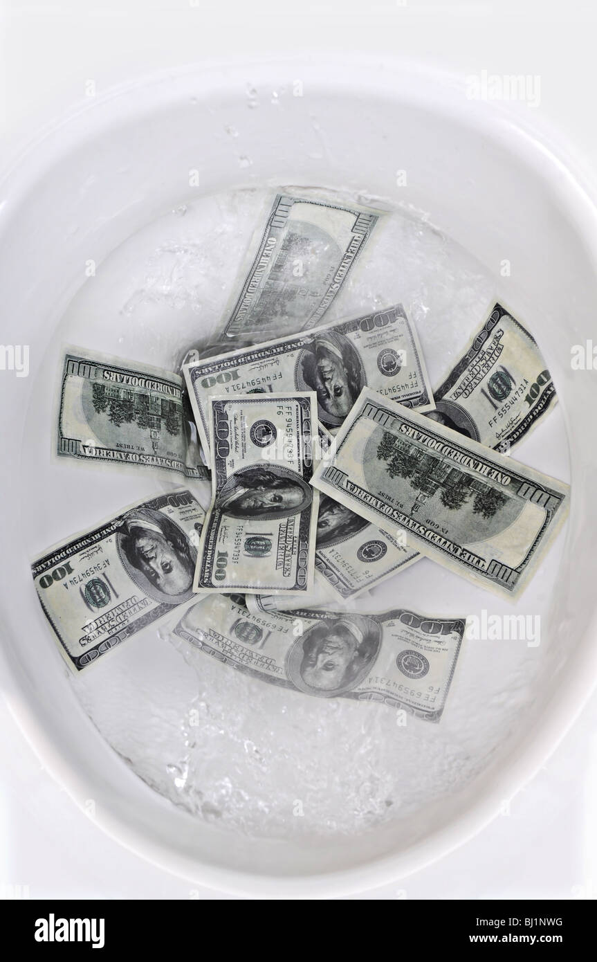 100 Dollar bills flushed into a toilet bowl. Stock Photo