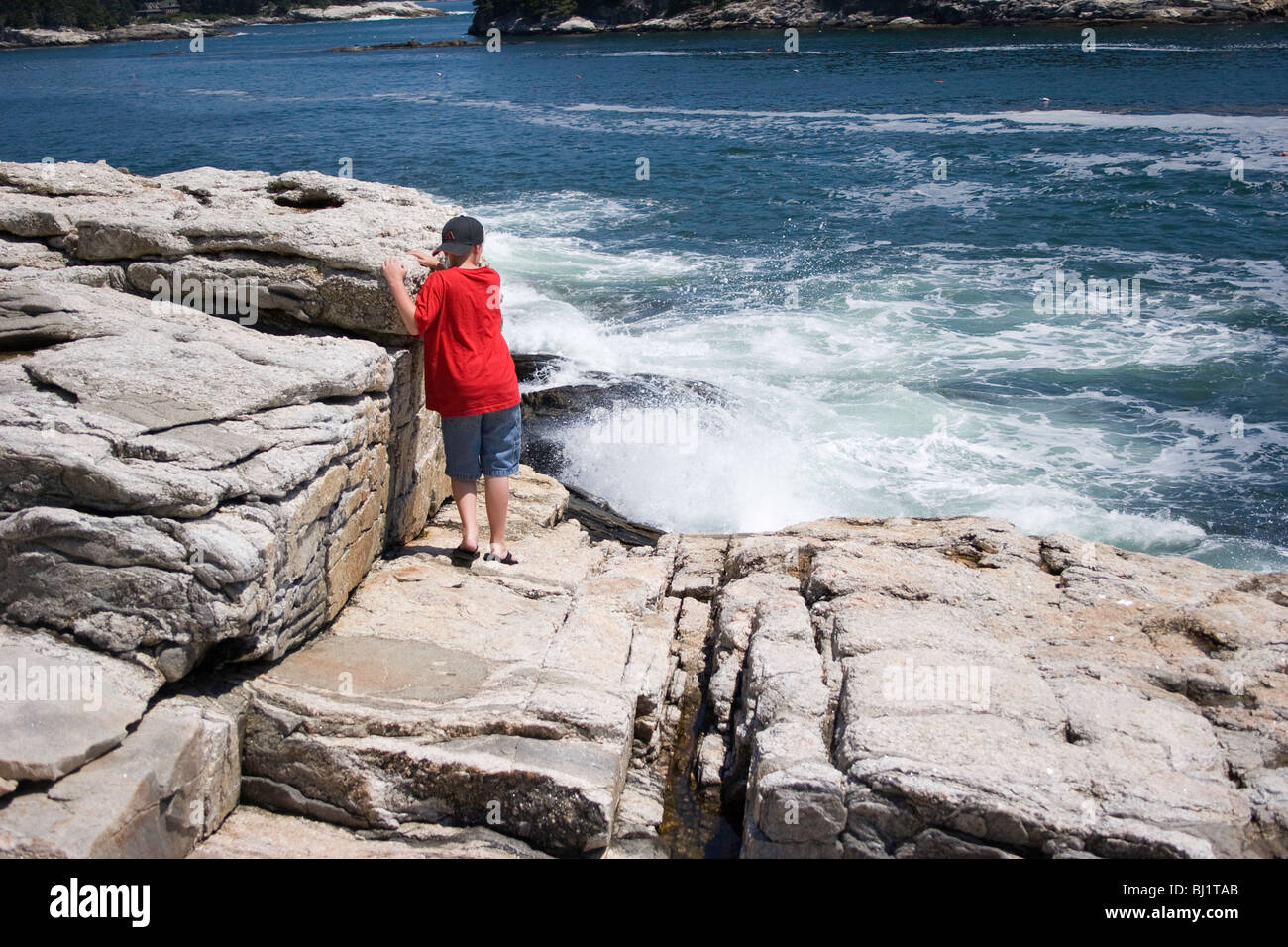 Boy Investigates the surf on the rocks at Five Islands, Maine Stock Photo Alamy