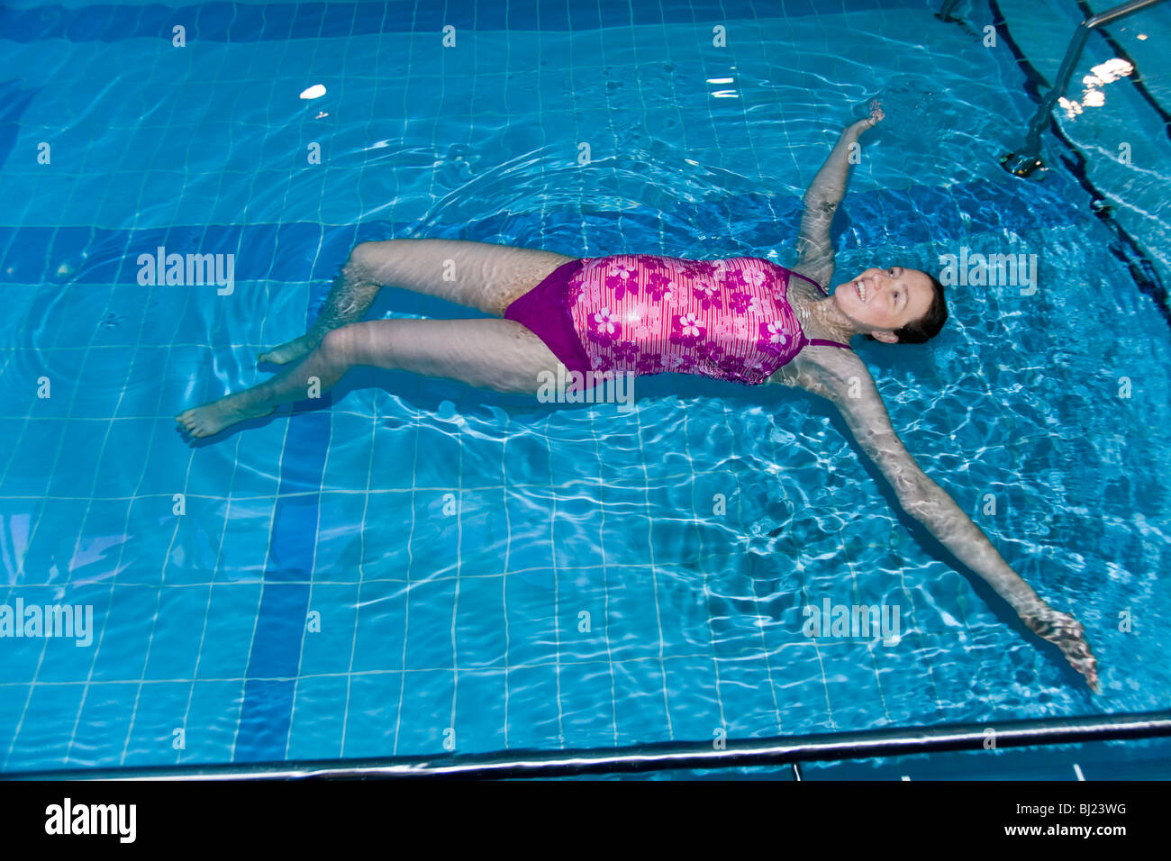 Pregnant woman swim / swimming / swims in a swimming pool. UK Stock ...