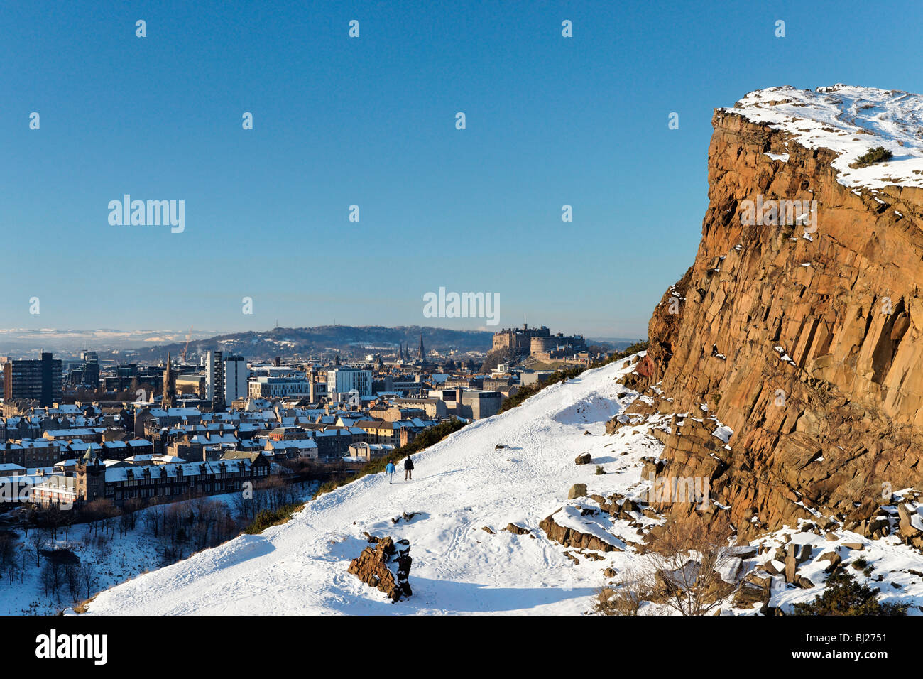 Walkers on Radical Road below Salisbury Crags with view to Edinburgh Castle, Scotland, UK. Stock Photo