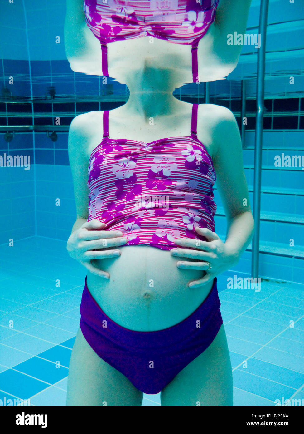 Pregnant woman swim / swimming / swims in a swimming pool. UK Stock Photo