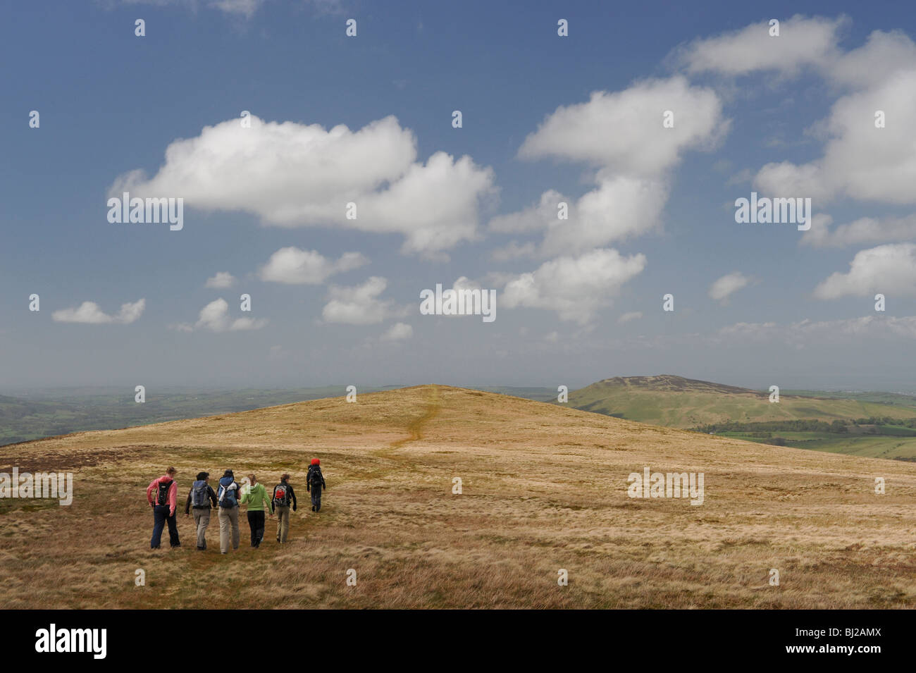 Walkers on the grassy summit of Great Cockup ; one of the Wainwrights in the northern English Lake District. Stock Photo