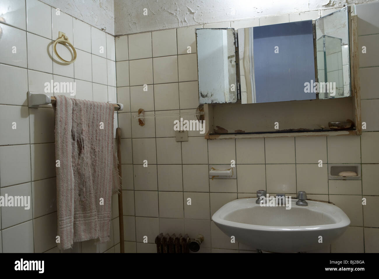 dirty towel, sink and bathroom in a run down bathroom Stock