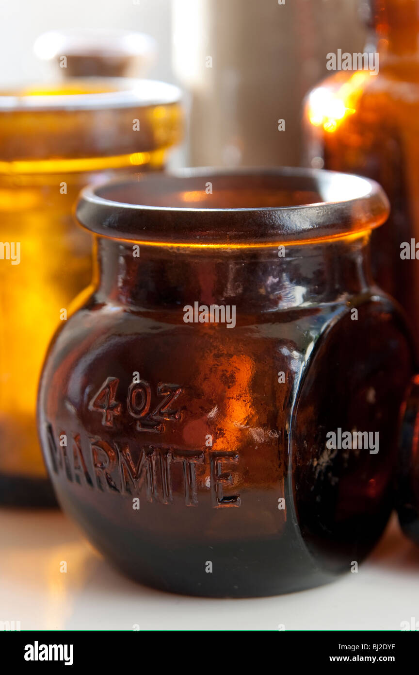 Old marmite jar with other glass bottles Stock Photo