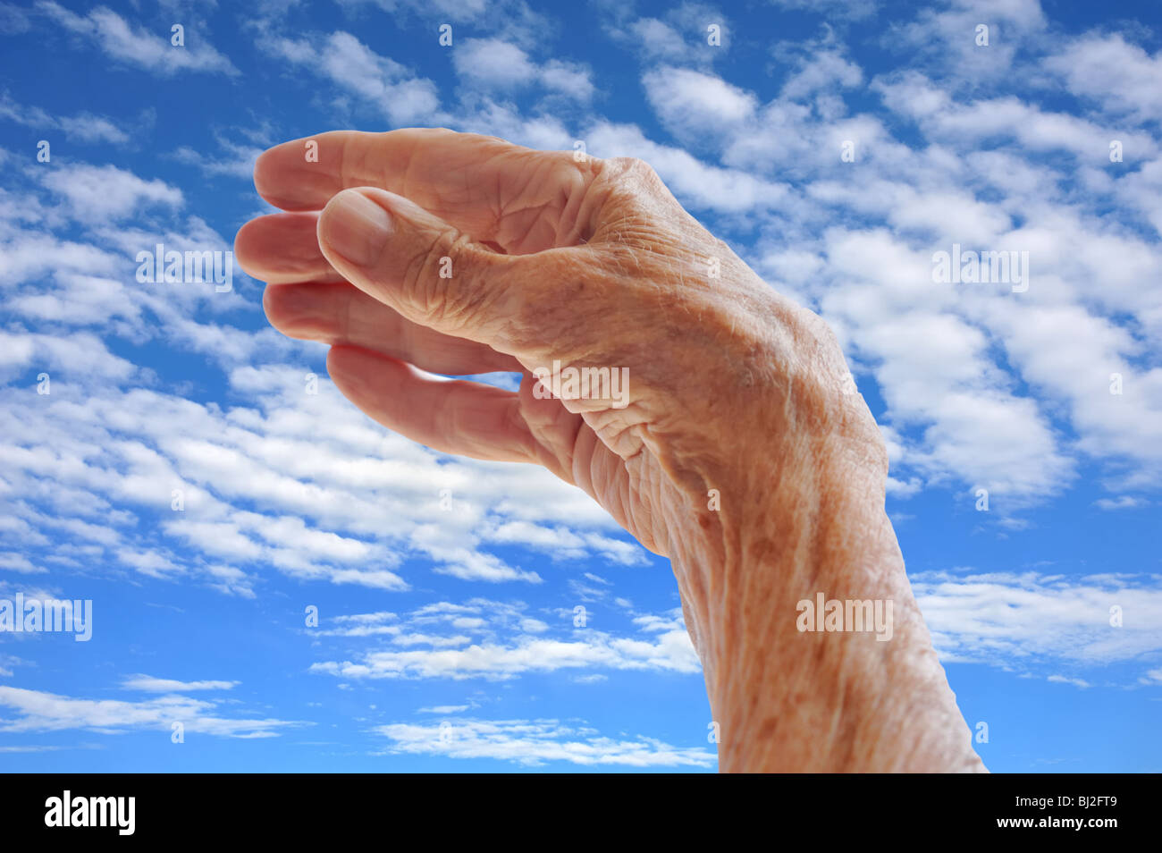Senior woman's hand over sky Stock Photo