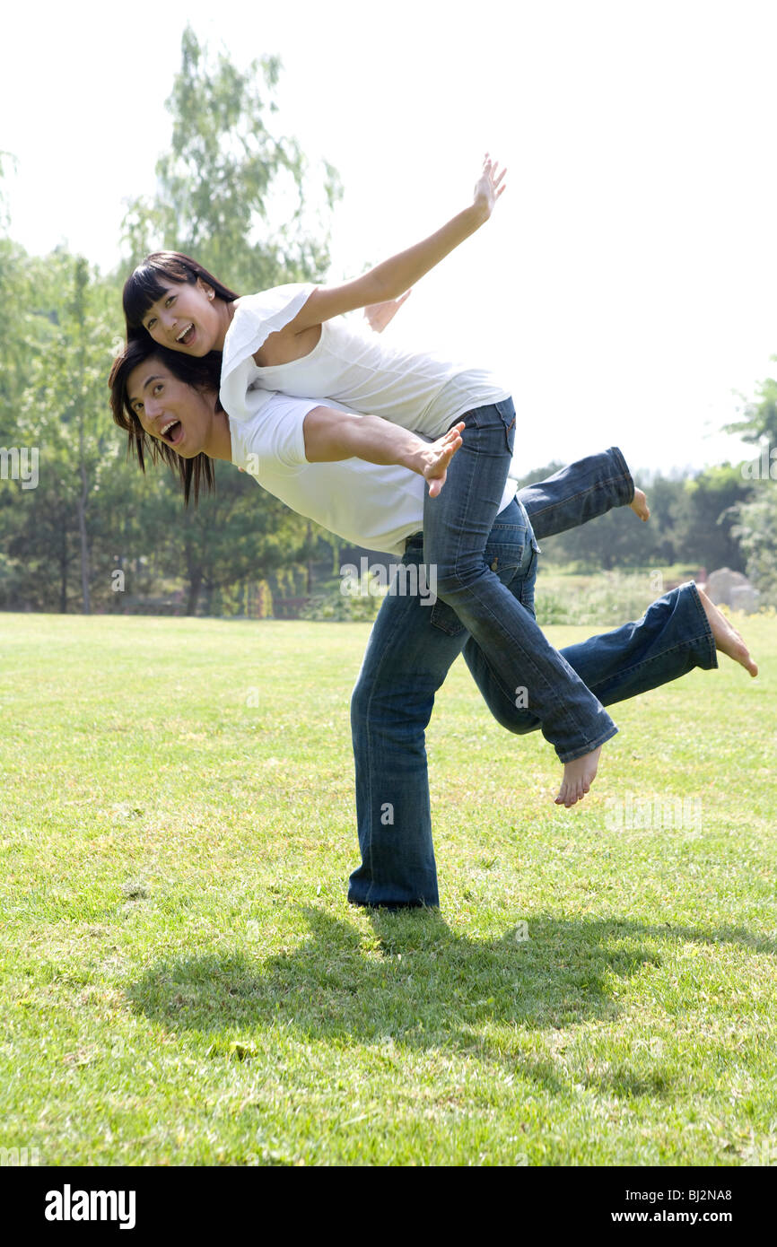 Young couple having fun in park Stock Photo - Alamy