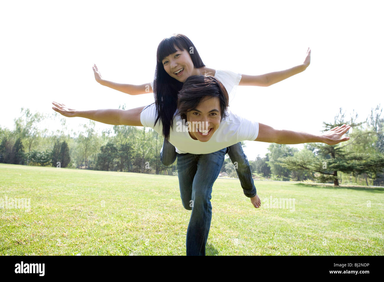 Young couple having fun in park Stock Photo - Alamy