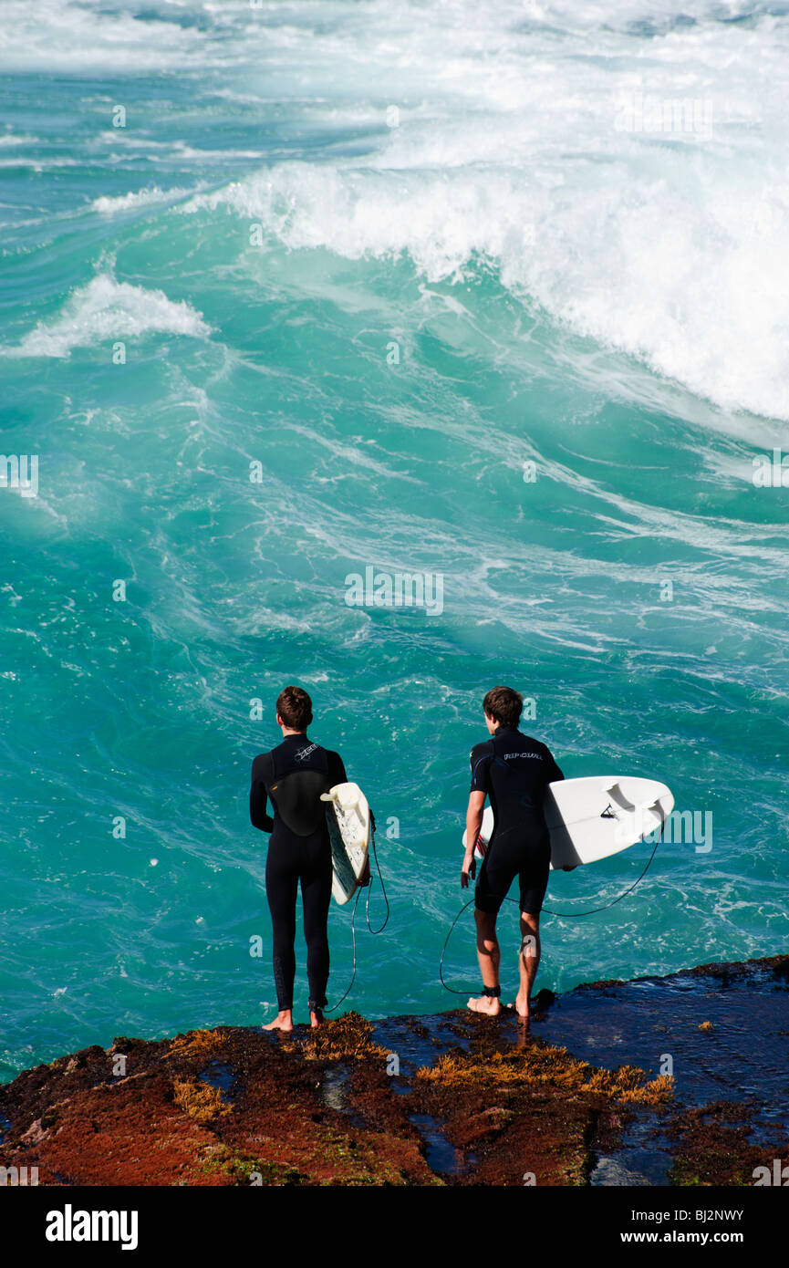 Surfers prepare to launch into the waves near Coogee beach, Sydney, Australia Stock Photo