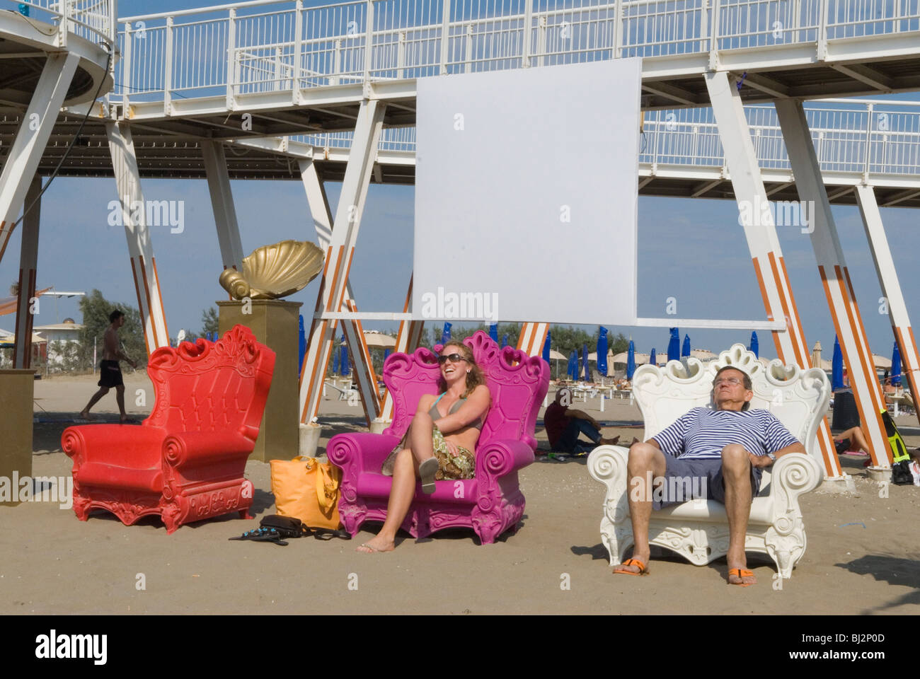Venice Italy Venice Lido the Blue Moon public beach. Tourists having fun in large plastic chairs. HOMER SYKES Stock Photo