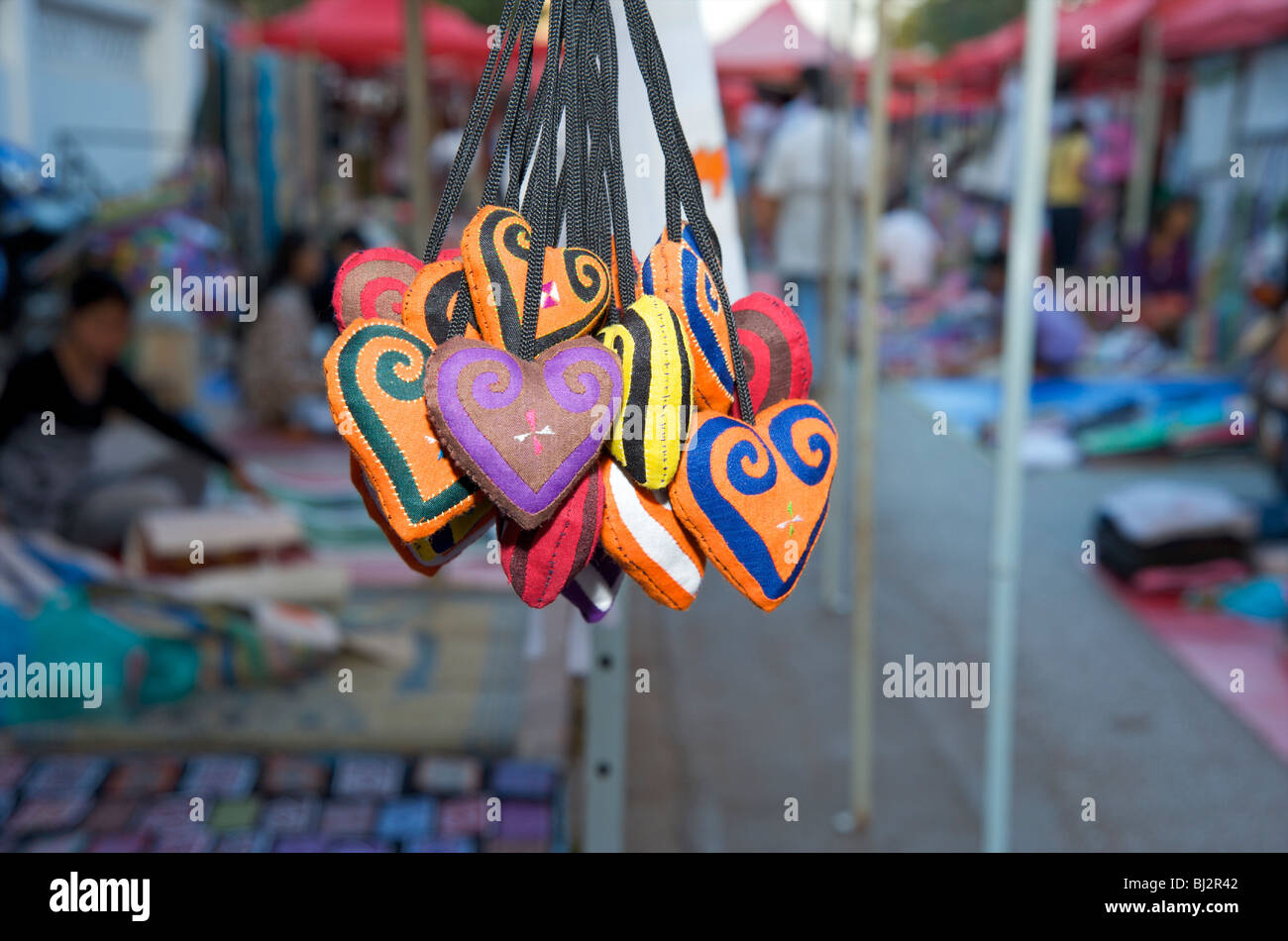 Tourist souvenirs hang from a street stall in Luang Prabang's nightly market Stock Photo