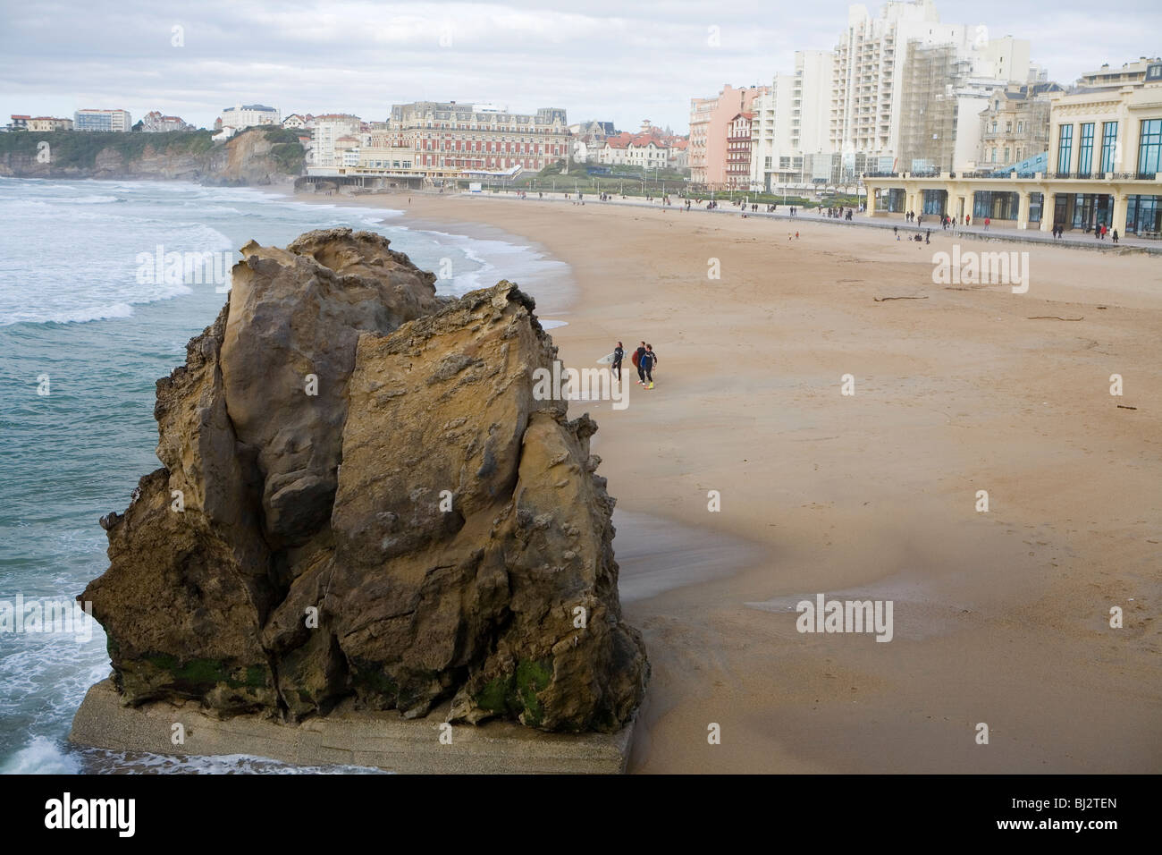Surfers heading for the waves on Grande Plage Stock Photo