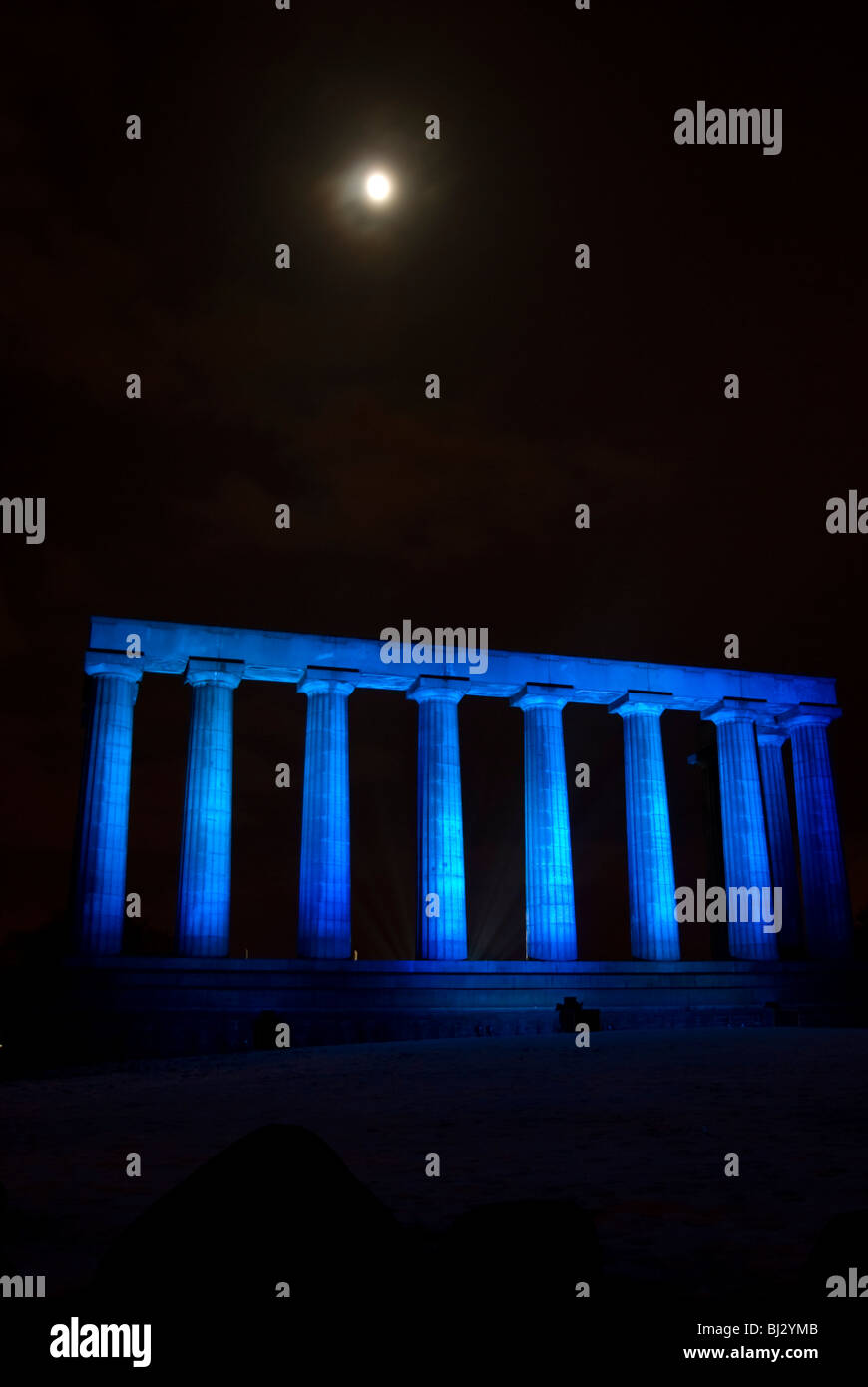 The Edinburgh Monument (aka Edinburgh's disgrace) on Calton Hill floodlit in blue, part of the city's Christmas celebrations. Stock Photo