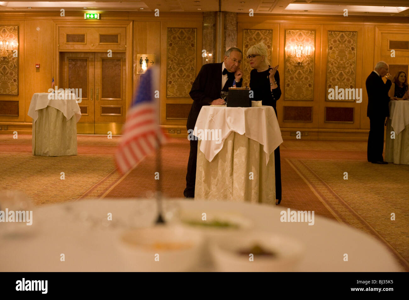 US citizens and Democrats Abroad party supporters talk in empty ballroom before others arrive to celebrate Obama's inauguration Stock Photo