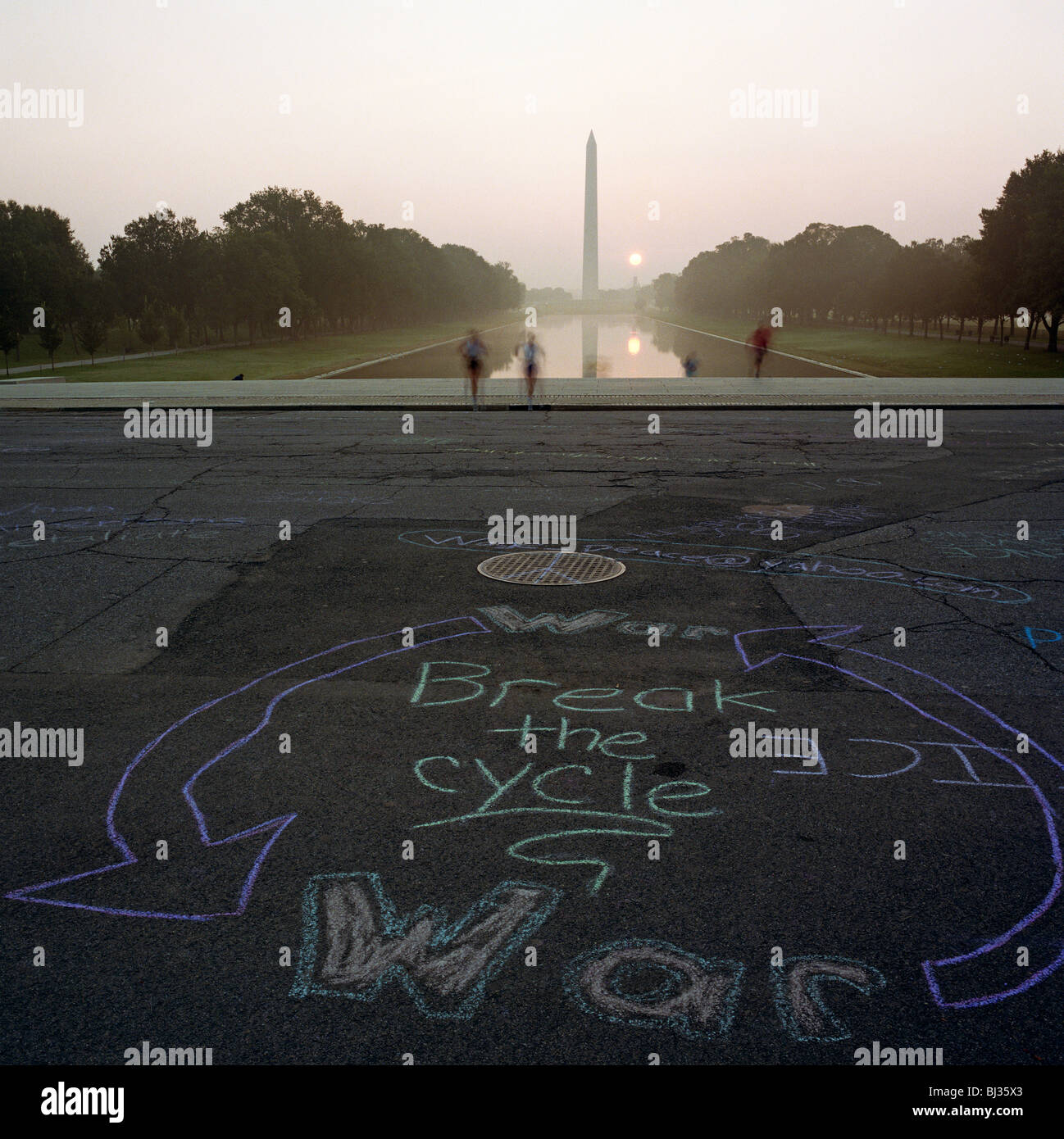 Anti-war graffiti written in a circular chalk graphic on the path in ...