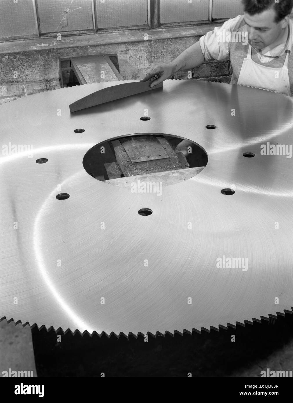 A machinist quality checking a six foot circular saw blade, Sheffield, South Yorkshire, 1963. Artist: Michael Walters Stock Photo