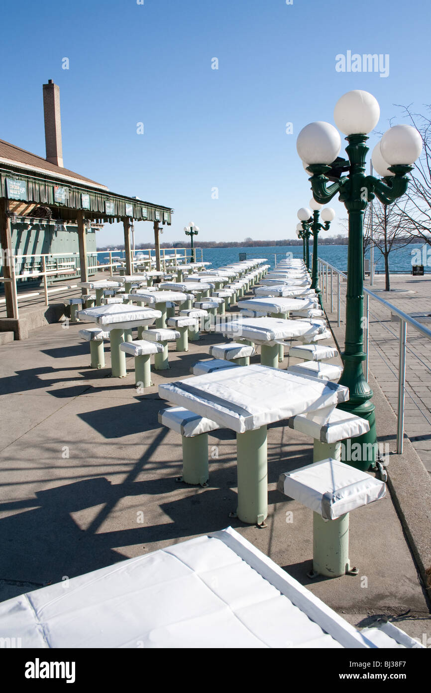 Outdoor patio tables and chairs covered for the winter months in a