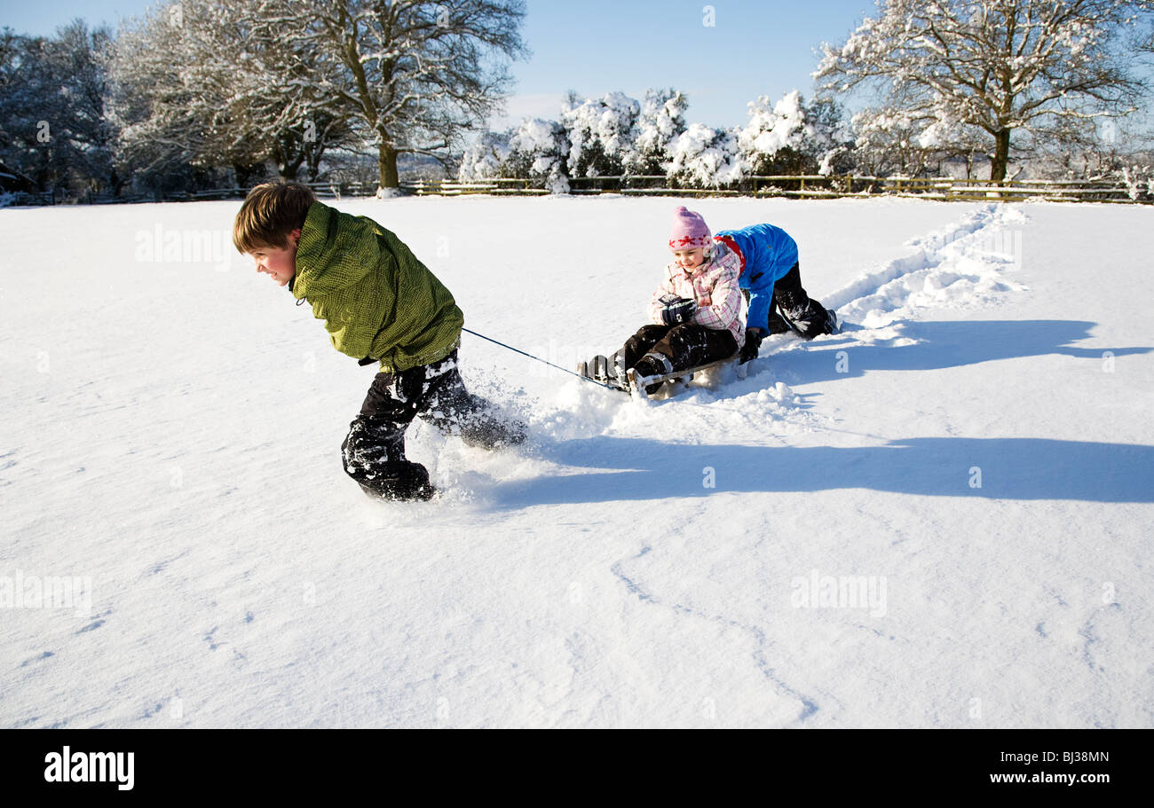 Children playing on sledge in the snow Stock Photo
