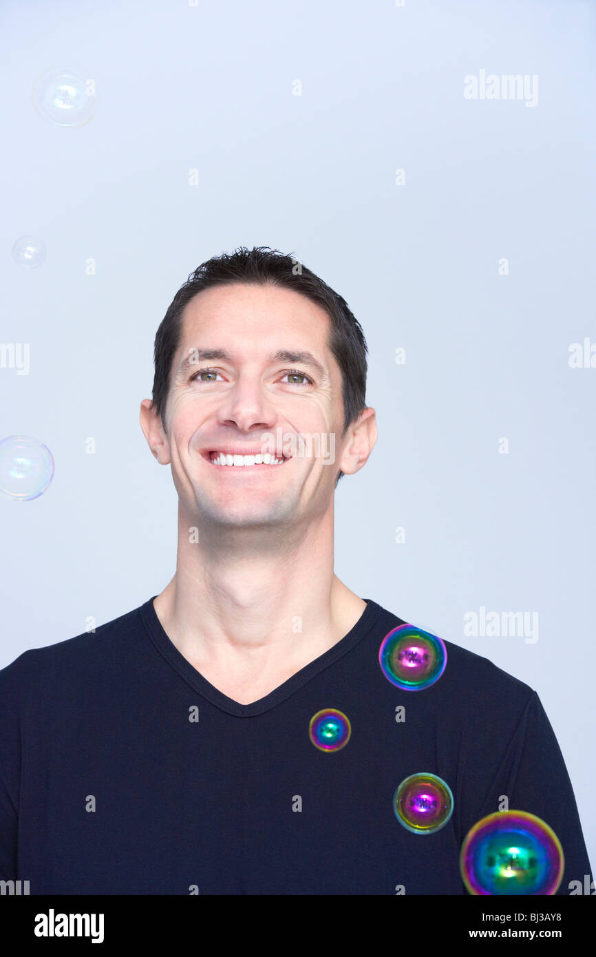 smiling man with soap bubbles around him Stock Photo Alamy
