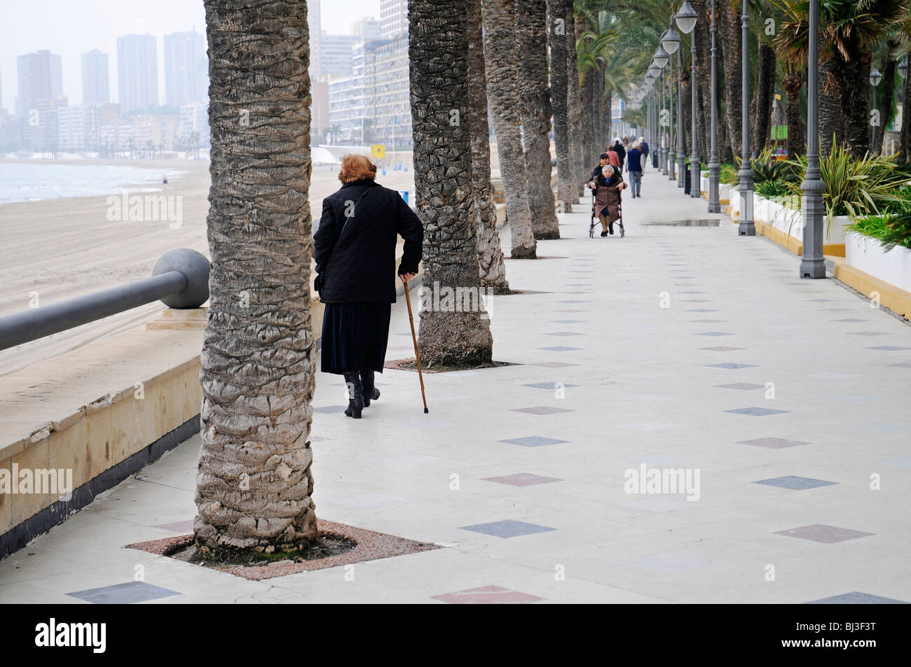 Old woman, cane, promenade, fog, cloudy, grey, bad weather, lonely, sad, Benidorm, Costa Blanca, Provinz Alicante, Spanien, Eur Stock Photo