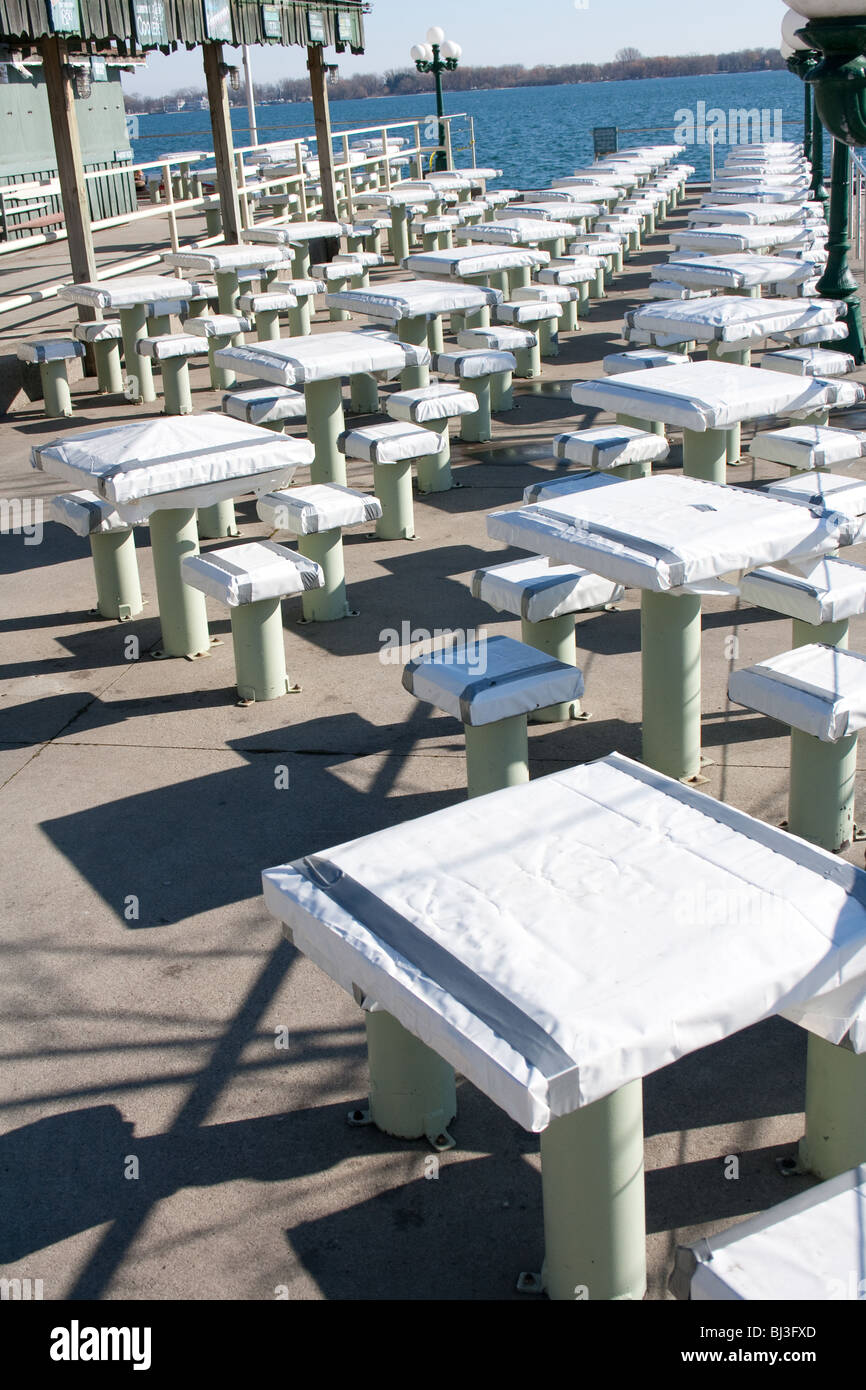 Outdoor patio tables and chairs covered for the winter months in a