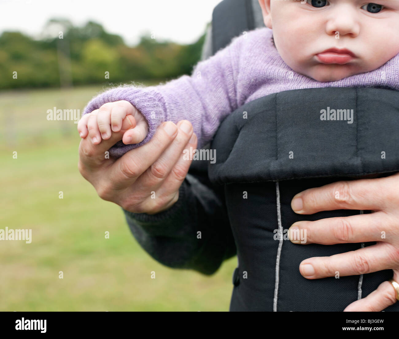 Baby holding grandfather's hand Stock Photo