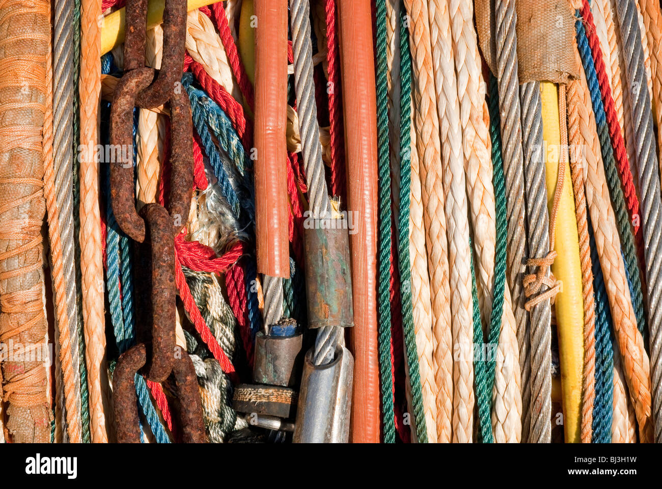 Multi coloured ropes and cables and chain for fishing boat Stock Photo