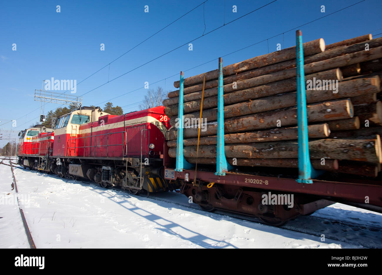 Old Finnish diesel electric locomotives ( type dv12  ) on railroad yard pulling log train full of spruce logs , Finland Stock Photo