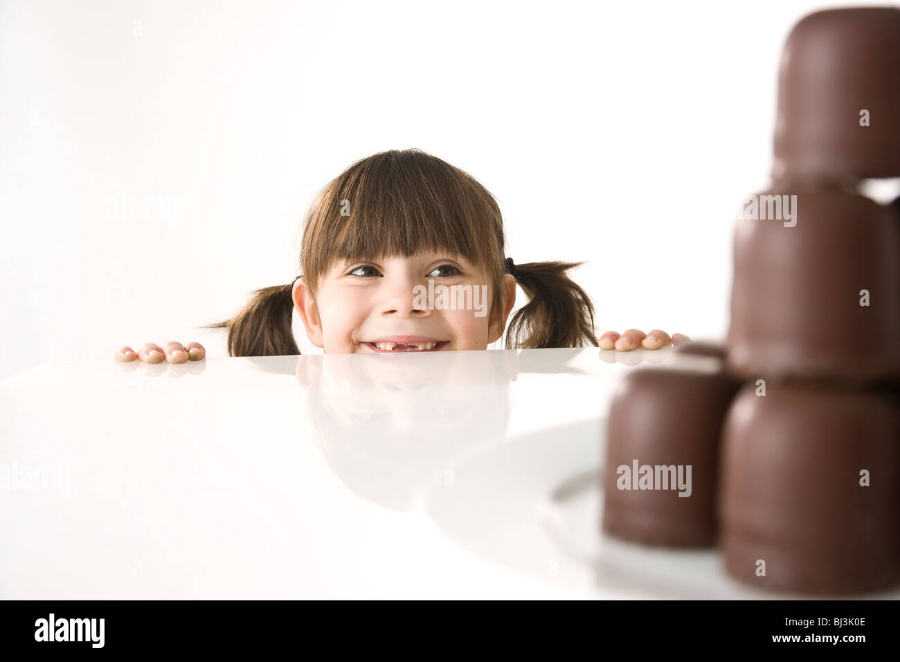 Girl in front of a plate of chocolate marshmallows Stock Photo Alamy
