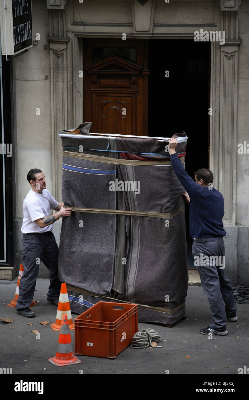 A Wardrobe Is Being Carried By Two Men During Removal Paris