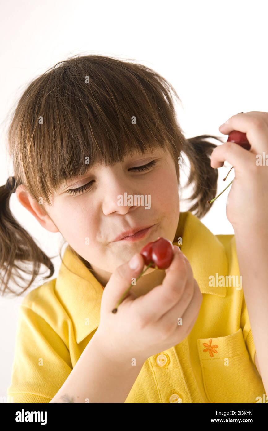 A little girl eating cherries Stock Photo Alamy
