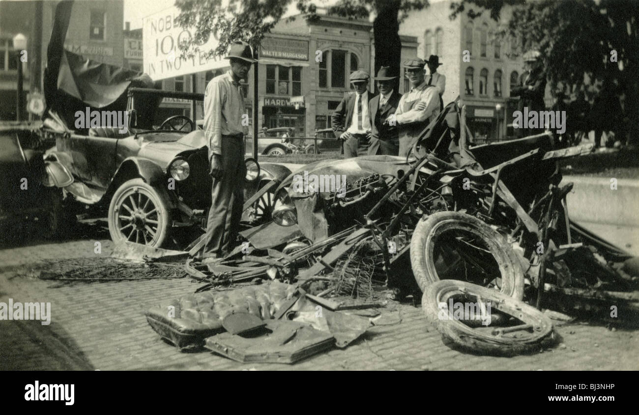 Onlookers gawk at the site of a two car accident in 1919. car accident small town site crash model-t ford antique fashion tires Stock Photo