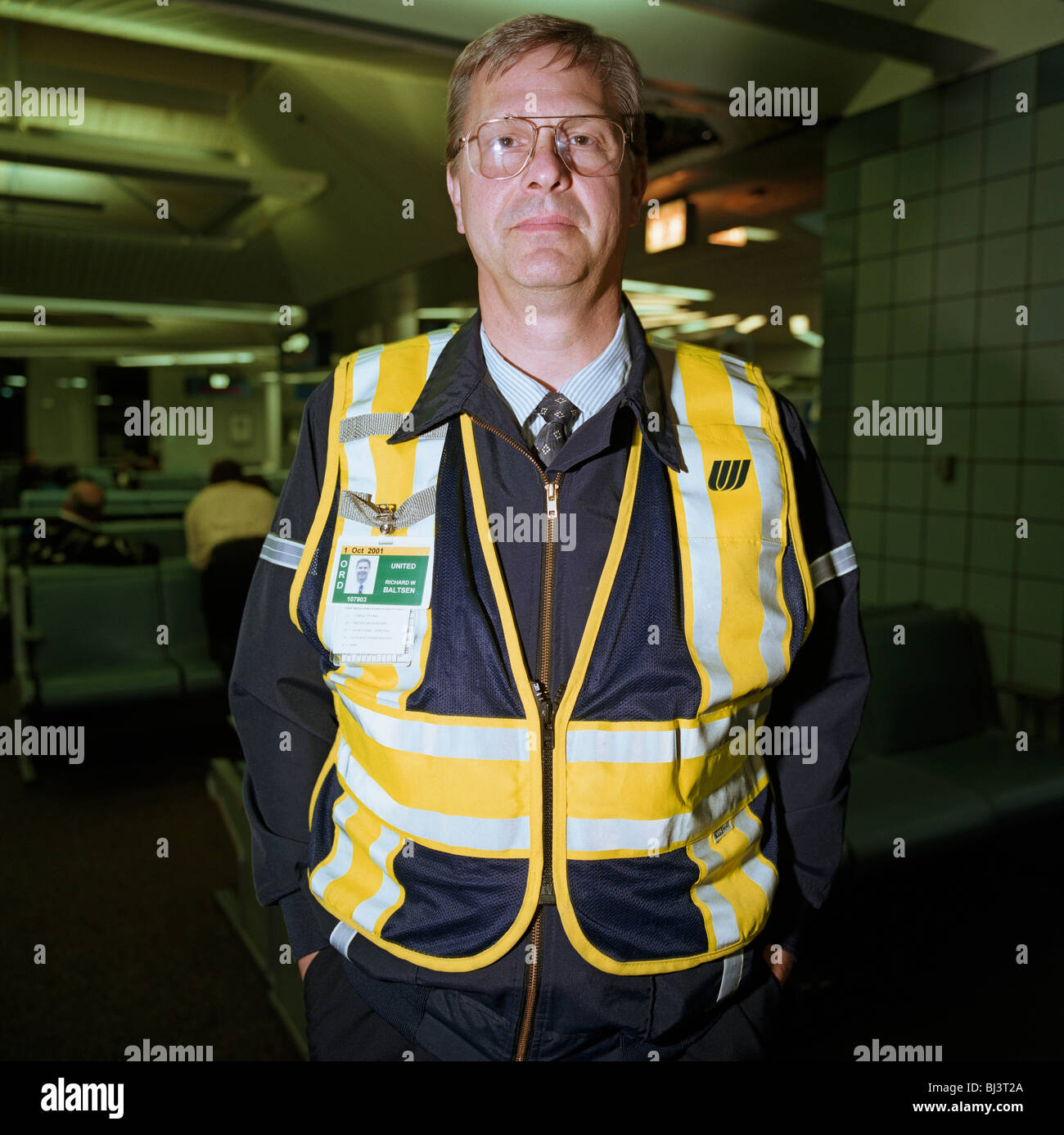 A United Airlines ramp agent stands in the terminal building of Chicago O'Hare airport before continuing his airside shift. Stock Photo