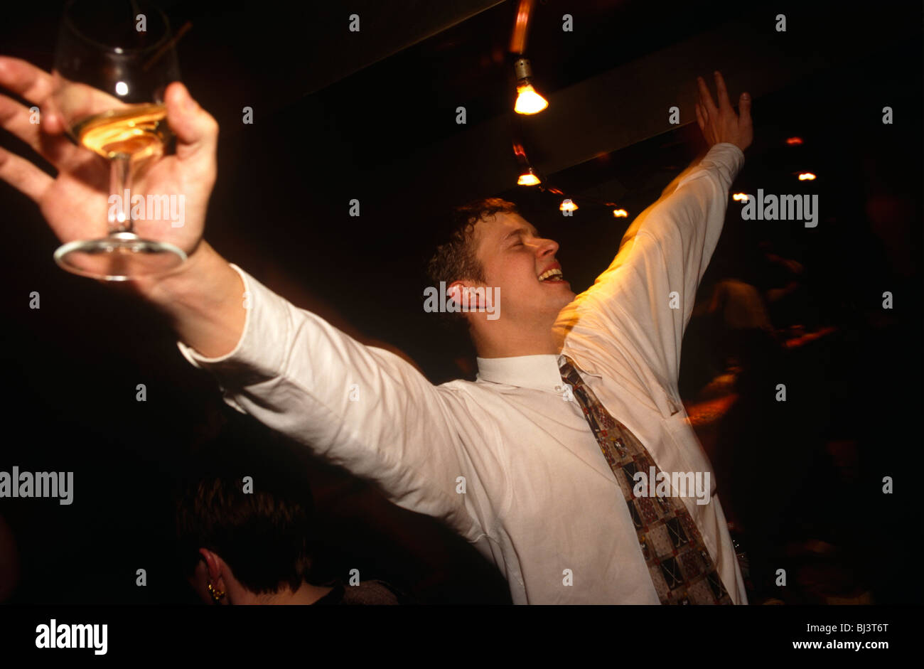 A young man in his twenties parties in the evening at a Coates Wine Bar