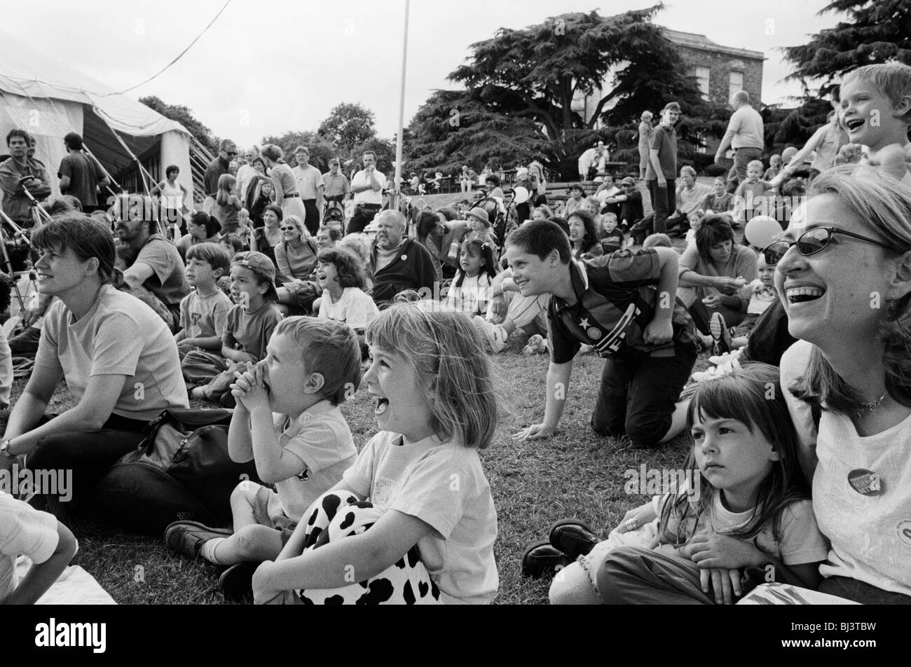 A crowd of Londoners laugh during an afternoon's Punch and Judy show at The Lambeth Show in Brockwell Park. Stock Photo