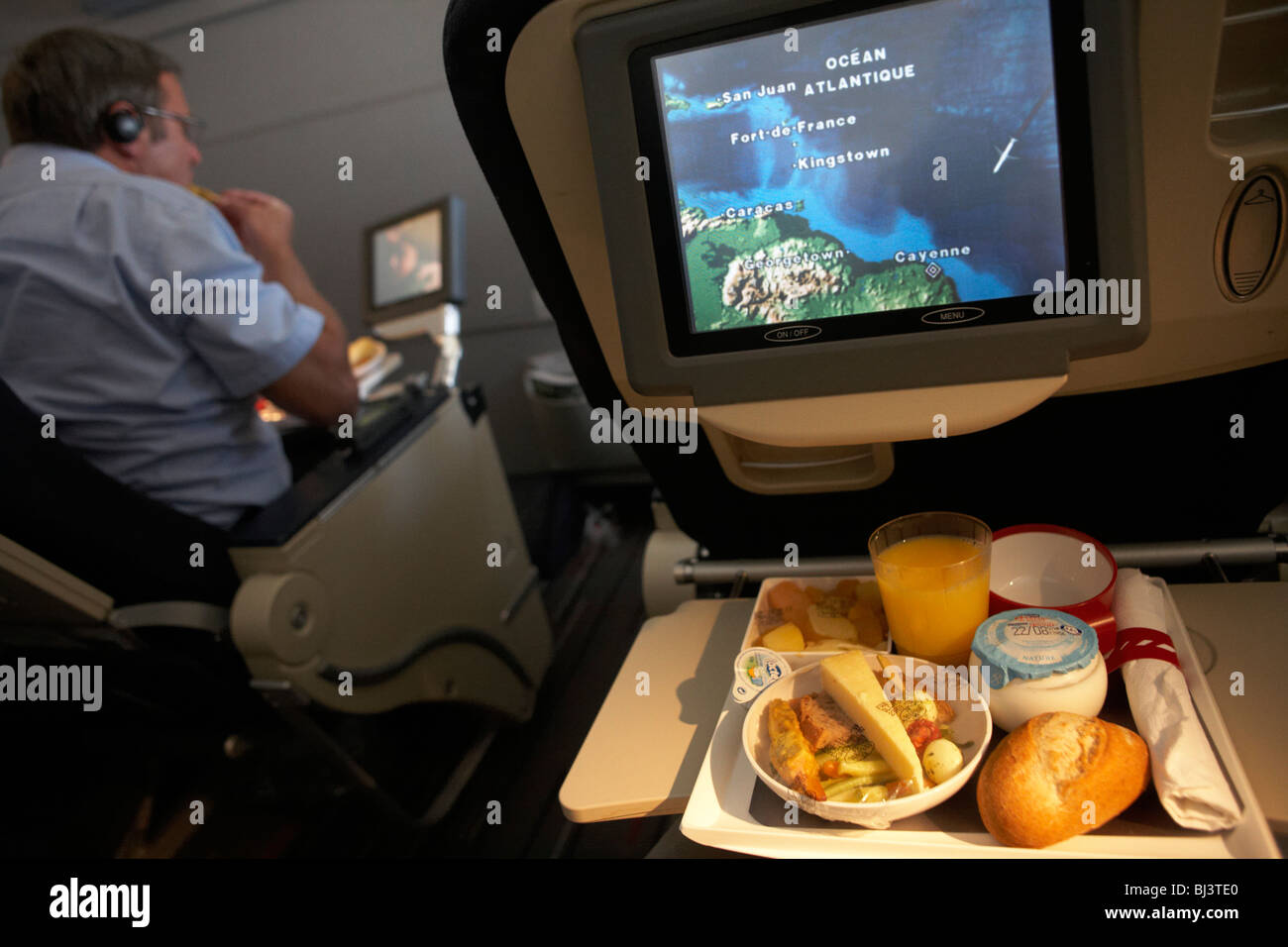 A man tucks in to his in-flight meal on-board an Air France Boeing 777 flight from Paris Orly to Cayenne, French Guiana. Stock Photo