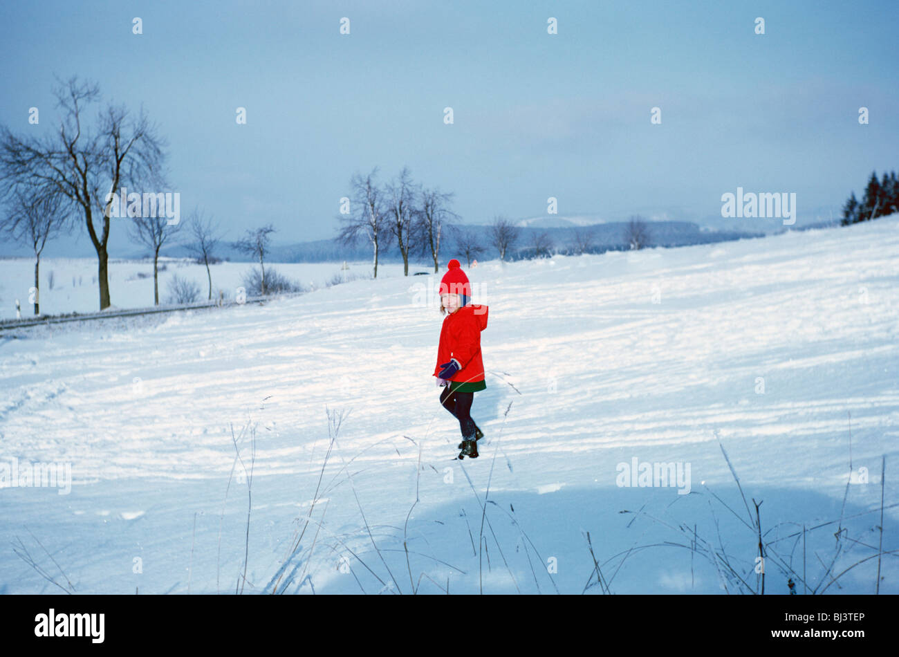 A four year-old girl stamps through fallen snow in a field near her home in Bielefeld, Germany in 1967. Stock Photo