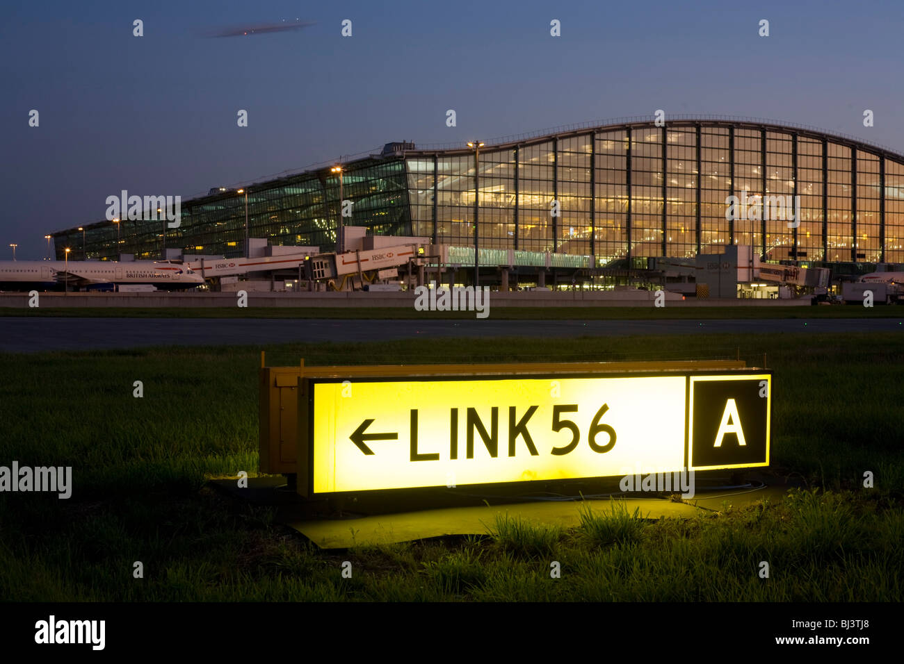 Exterior view of Heathrow Airport's Terminal 5 building with airfield navigation taxiway sign. Stock Photo
