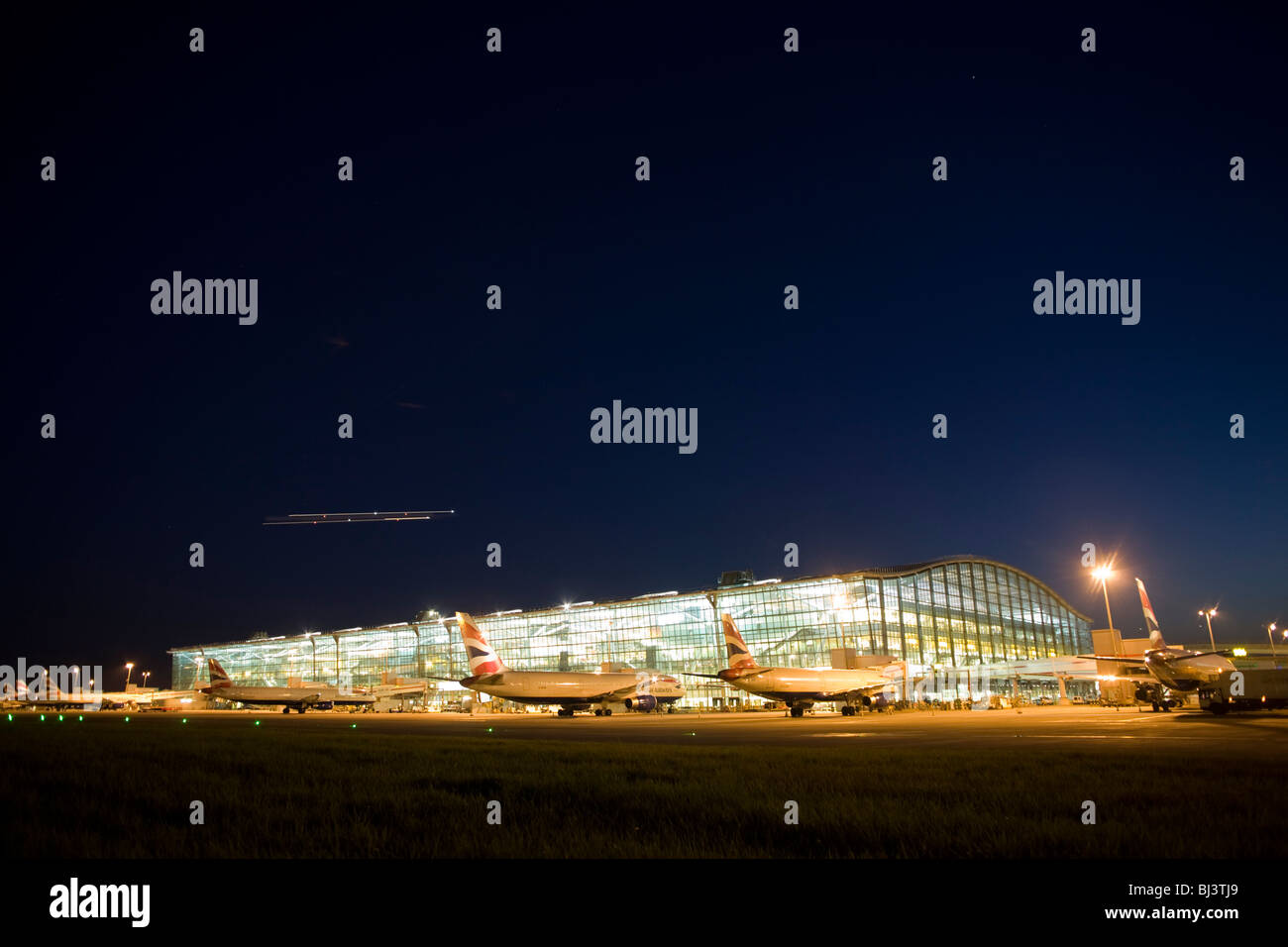 Faint traces of evening meteor shower in the sky, a wide exterior view of Heathrow Airport's Terminal 5. Stock Photo
