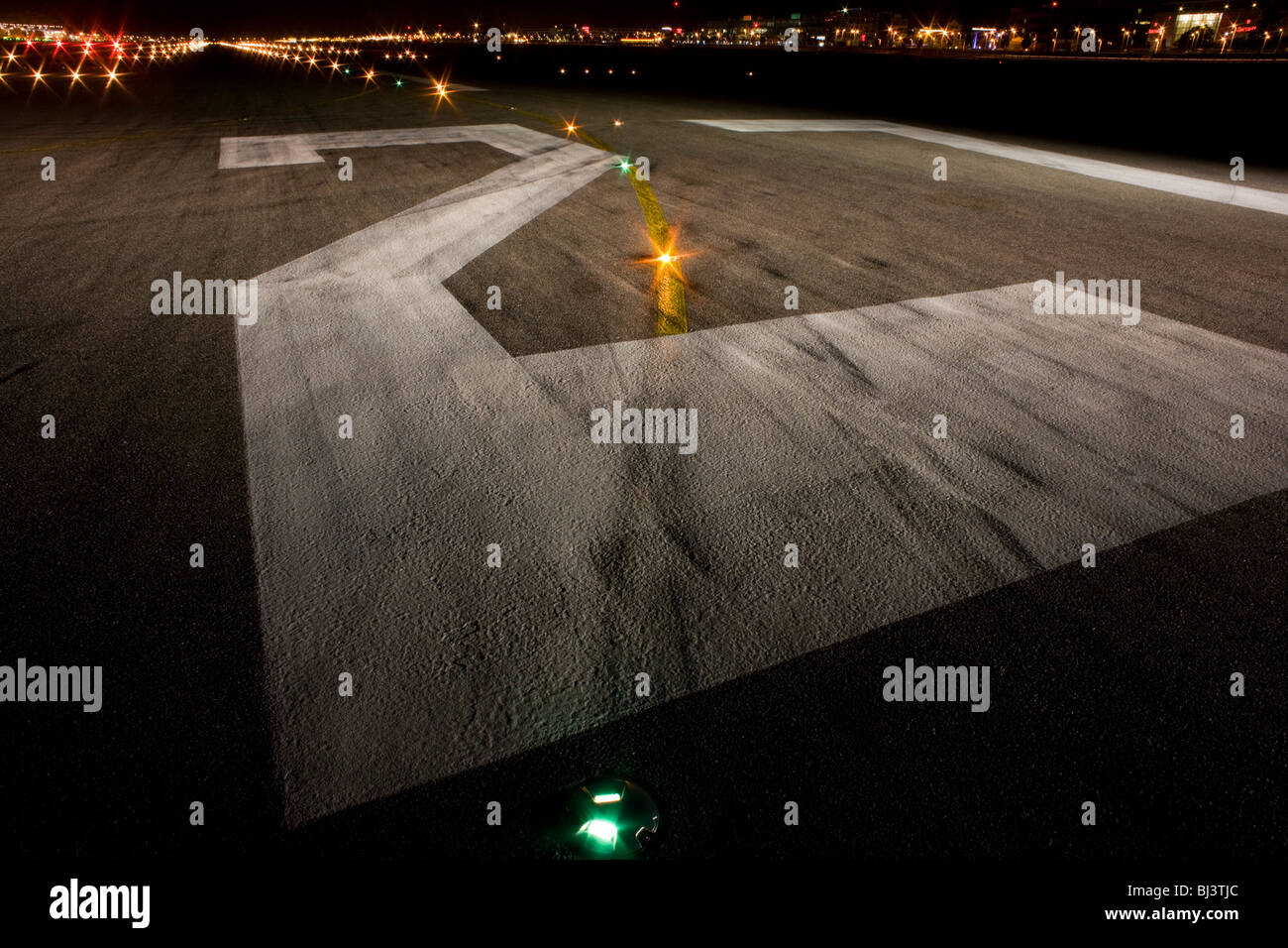A wide night view looking down on the rubber-stained runway 27R at Heathrow Airport. Stock Photo