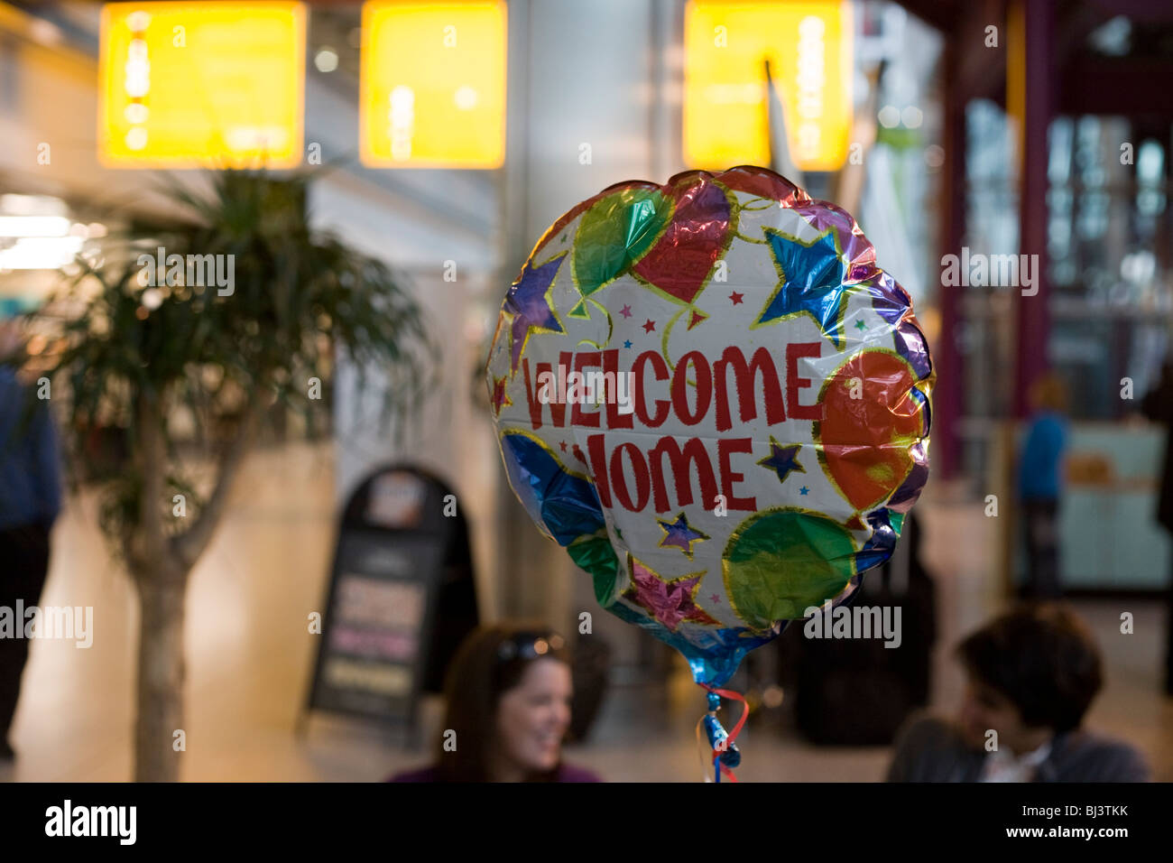 A helium-filled Welcome Home balloon floats in the air in Heathrow Airport's Terminal 5 arrivals hall. Stock Photo