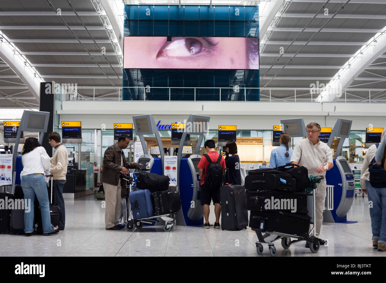 A scene of busy modern air travel as international passengers check-in at the British Airways Heathrow Airport's Terminal 5. Stock Photo