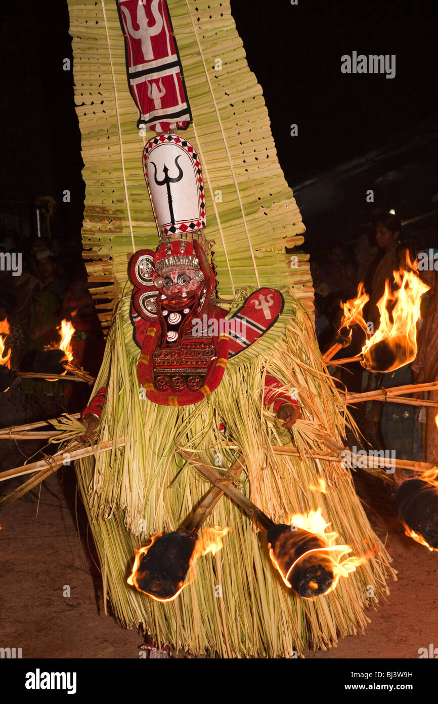 India, Kerala, Cannanore (Kannur), Theyyam, ancient ritual Agni-Ghandakaran dancing in trance surrounded by flaming torches Stock Photo