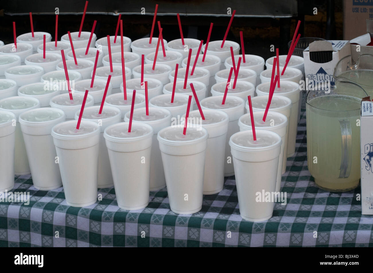 White styrofoam cups with red straws and a pitcher of lemonade. Stock Photo